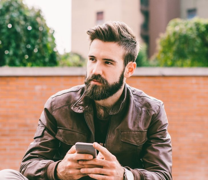 Young bearded man using smartphone